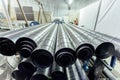 Cylindrical steel pipes. Round metal tubes in metalworking workshop