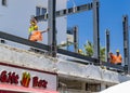 CYPRUS, Kyrenia - JUNE 10, 2019: Builders are building a new building on the roof. Workers dressed in orange vests and yellow