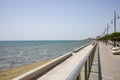 Cyprus, Larnaca city. Stone path around and above the sea. Port, beach, buildings, blue sky backdrop.