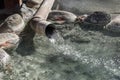 Cystal clear hot mineral water is pouring from pipe in a small pond outdoor Onsen Royalty Free Stock Photo