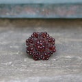 Czech garnet antique flower star brooch on grey background Royalty Free Stock Photo