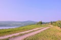 Czech landscape with meadow path leading to new lake named Milada and mountains in spring morning Royalty Free Stock Photo