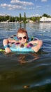 A child with a circle bathes in the lake. A boy in goggles with an inflatable ring swims in the lake Royalty Free Stock Photo