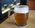 Czech Republic, Prague, April 7, 2018: full pint glass of Staropramen premium czech beer on wooden restaurant table, selective