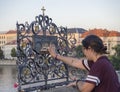 Czech Republic, Prague , September 8, 2018: Young woman tourist touching the falling priest Saint John of Nepomuk on the