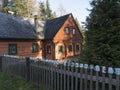 Czech Republic, Vlci Hora, November 30, 2019: Beautiful orange green wooden timbered house or cottage with fence covered