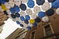 Czech street in Brno. view upwards, between tall houses hanging on a rope colored umbrellas in yellow, blue, white