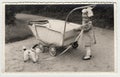 A small girl with dog toy and pram (baby carriage), circa 1942