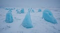 Blue ice formations rise from a snow-covered landscape, resembling natural sculptures. Royalty Free Stock Photo