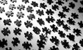 Black jigsaw puzzle pieces are scattered randomly on a white surface Royalty Free Stock Photo
