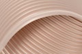 3D abstract background with a brown shade of peach cream, consisting of overlapping wavy ribbed surfaces