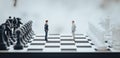 3d Businessmen standing on a chess board and two of them shaking hands. 3D illustration