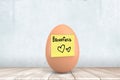 3d close-up rendering of chicken egg with yellow sticky note on with hand-drawn hearts and word `Breakfast`