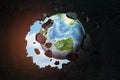 3d close-up rendering of planet Earth punching big hole in black wall with blue sky peeking though hole.