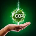 A 3D CO2 emission reduction concept, Environmental icons CO2 green color in adult hand on green background, Royalty Free Stock Photo