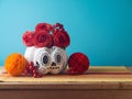 DÂ­a de los Muertos day of the dead holiday concept. Sugar skull Halloween pumpkin and Mexican party decorations on wooden table