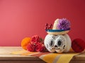 Da de los Muertos day of the dead holiday concept. Sugar skull Halloween pumpkin and Mexican party decorations on wooden table