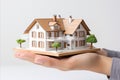 3d house model resting in human hands conceptual image illustrating insurance and bank loan