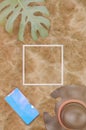 3d illustration. Beach Sand background . Straw hat , Tropical leaf and mobile phone on a sandy background, top view . White line