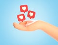 3D illustration of cartoon human hand and like heart icons on a red pins flying around over palm. Social media concept, web icon Royalty Free Stock Photo