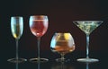 3d illustration of cognac, white wine, red wine, martini glasses in row on dark backgroun Royalty Free Stock Photo