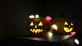 3D illustration, 3D rendering, The head of a scary demon pumpkin Decorated with lights on a wooden table