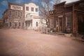 3D illustration of an empty street in an old wild west town with wooden buildings Royalty Free Stock Photo