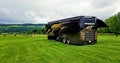 3D illustration of a luxurious Entegra motorhome at a field during a family vacation travel