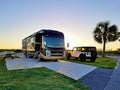 3D illustration of a luxurious Entegra motorhome vehicle at a beach during a family vacation travel