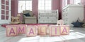 The name amalia written with wooden toy cubes in children`s room