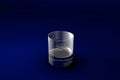 3D illustration of old fashioned whiskey glass on dark blue design background - drinking glass render