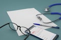 Paper, glasses, mobile, pen and  stethoscope on pale blue tabletop Royalty Free Stock Photo