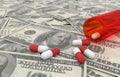 Pills over dollars bills with white background Royalty Free Stock Photo