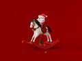 Santa Claus riding rocking horse on red background Royalty Free Stock Photo