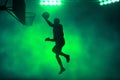 3d illustration shadow silhouette of professional basketball player layup on dark green smoke backgrounds