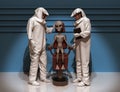 Scientists in protective suits examining an alien