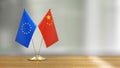 European Union and Chinese flag pair on a desk over defocused background