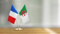French and Algerian flag pair on a desk over defocused background