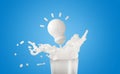 3d milk or yogurt ripple splash in the glass with light bulb isolated on blue background. idea tip concept, 3d render illustration Royalty Free Stock Photo