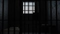 3D model of a solitary prison cell behind bars with a bed and a table and a window with light Royalty Free Stock Photo