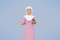 3d muslim woman greeting, pointing,holding phone while smiling. 3d illustration. 3d rendering. 3d potrait
