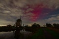 Purple coloured aurora borealis or northern lights over a dutch windmill. Royalty Free Stock Photo