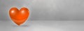 3D orange heart on a concrete studio banner
