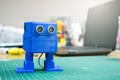 3D printed Funny blue robot on the background of devices and laptop. Robot model printed on automatic three dimensional 3d Royalty Free Stock Photo