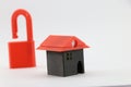 3D printed miniature house with an open padlock on a background showing the concept of a home free from mortgage, Real estate