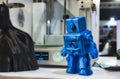 3D printed robot model next to a 3d printer