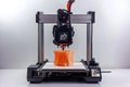 3 d printer in operation creating an orange object in a studio setting Royalty Free Stock Photo