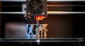 A 3D printer creates a complex, abstract structure on a printing bed. The machine