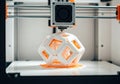 3D printer creating intricate geometric shape with vibrant orange filament, showcasing advanced technology and precision in a Royalty Free Stock Photo