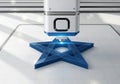 Printer extrudes a blue six-pointed star, layer by layer, on a grid-marked Royalty Free Stock Photo